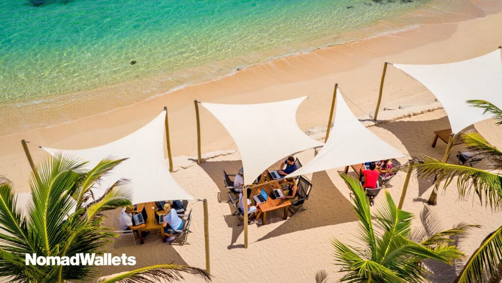 Digital Nomad Visas Africa and Middle East 2025 (Guide) 2 Aerial view of Cape Verde island beach with clear waters and digital nomads working outdoors in a shaded beachfront coworking space.