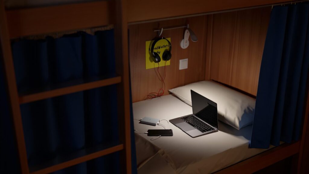 Best Devices for Digital Nomads to Pack for Long-Term Travel (2025 Guide) 4 Digital nomad working late in hostel bed with tech gear