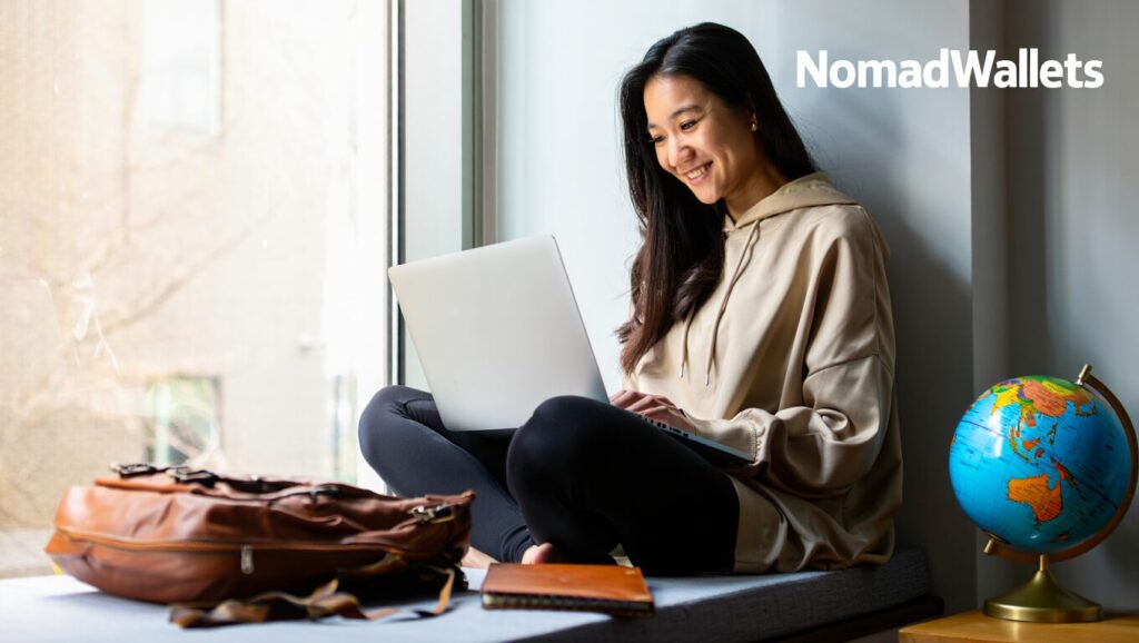 The Digital Nomad Lifestyle: What It’s Really Like in 2025 2 Young Asian digital nomad working from an Airbnb window seat — balancing freelance work and travel in 2025.